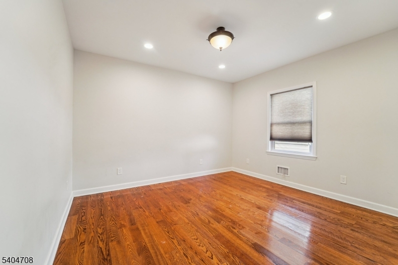 204 Harrison Street Nutley, NJ 07110 - Photo 18 of 23 an empty room with wooden floor and windows