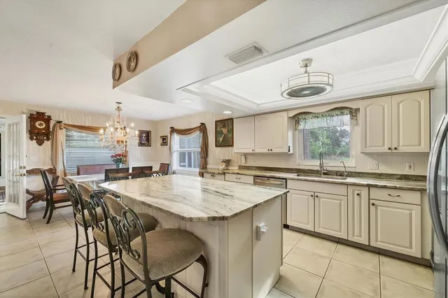 a kitchen with center island table chairs sink and cabinets