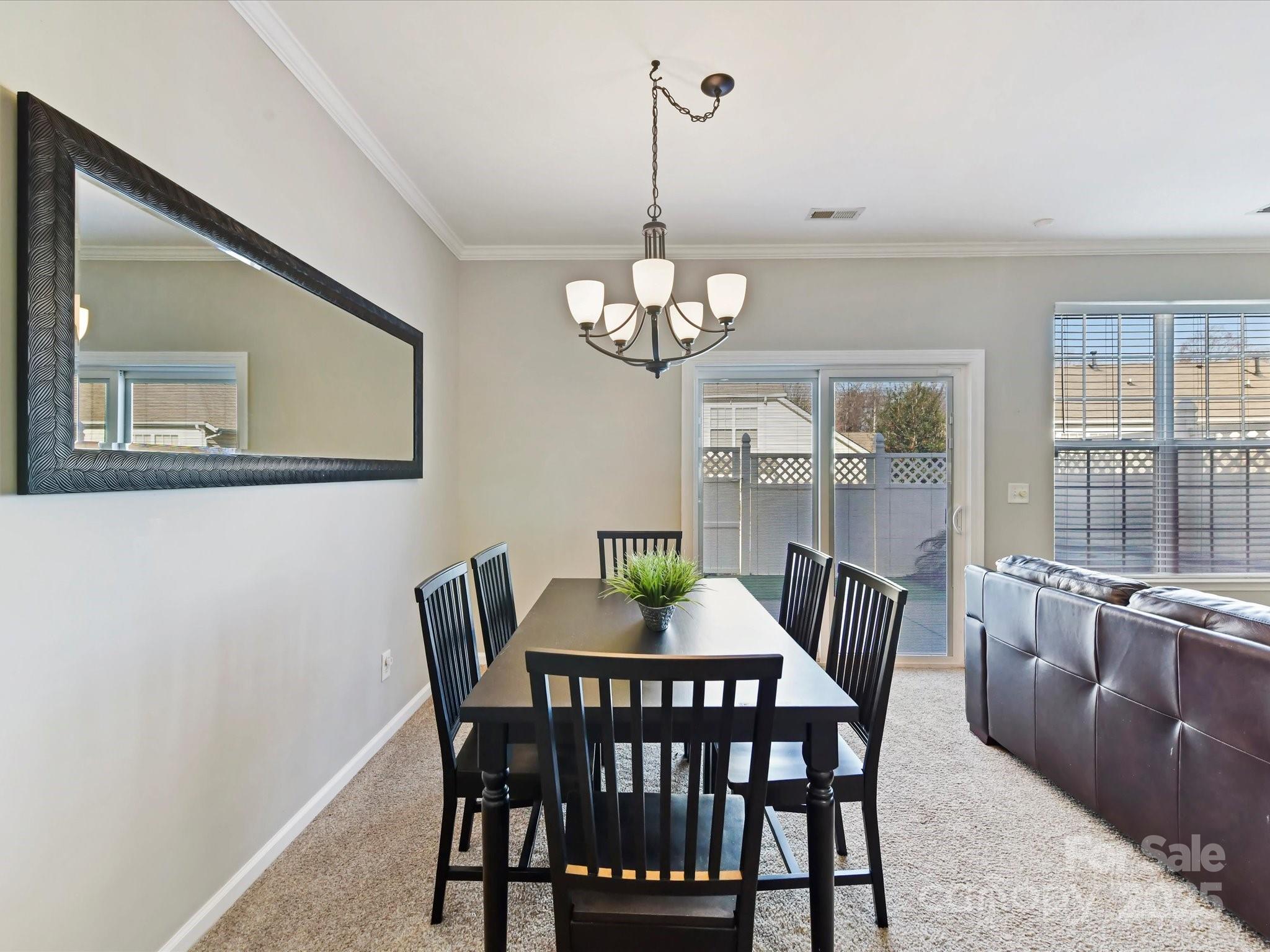 836 Gentlewinds Court Fort Mill, SC 29708 - Photo 10 of 29 a view of a dining room with furniture a chandelier and wooden floor