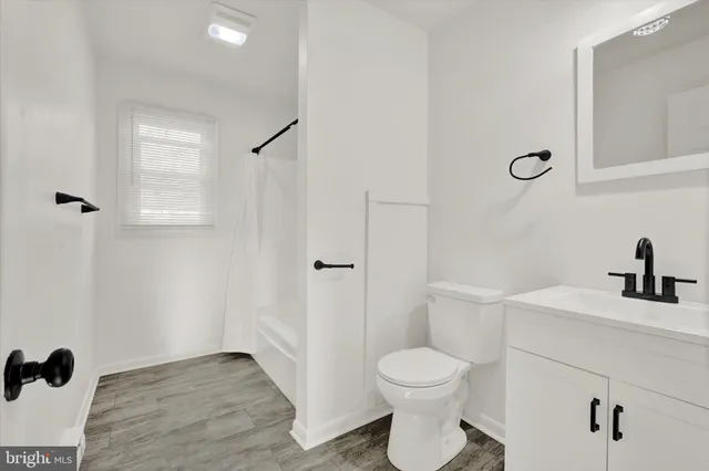 a bathroom with a toilet a sink and mirror