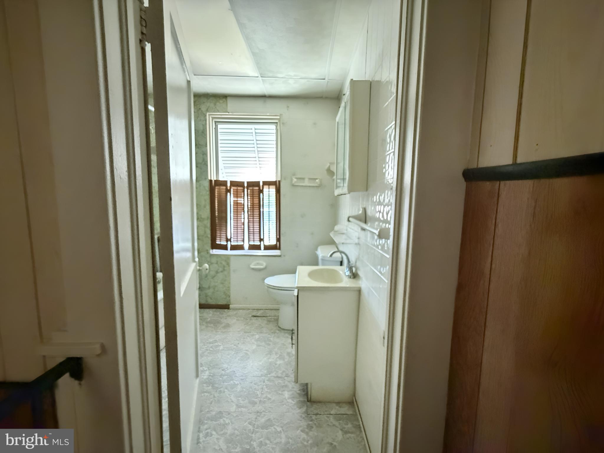 2802 Brighton Street Baltimore, MD 21216 - Photo 13 of 38 a bathroom with sink a mirror a toilet and bathtub