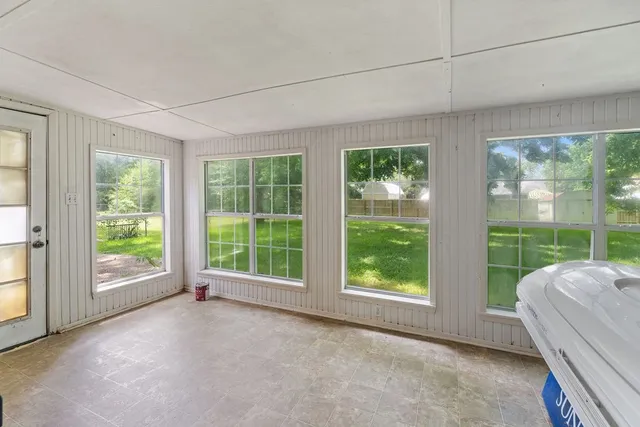 a bedroom with a bed and large window