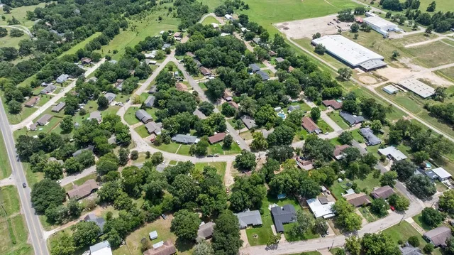 an aerial view of residential houses with outdoor space and trees