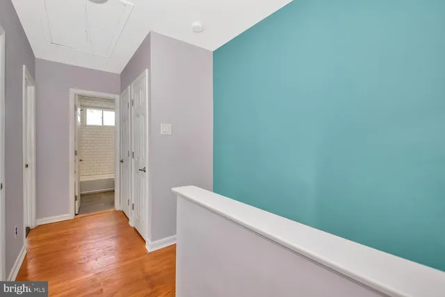 a view of hallway with closet and wooden floor