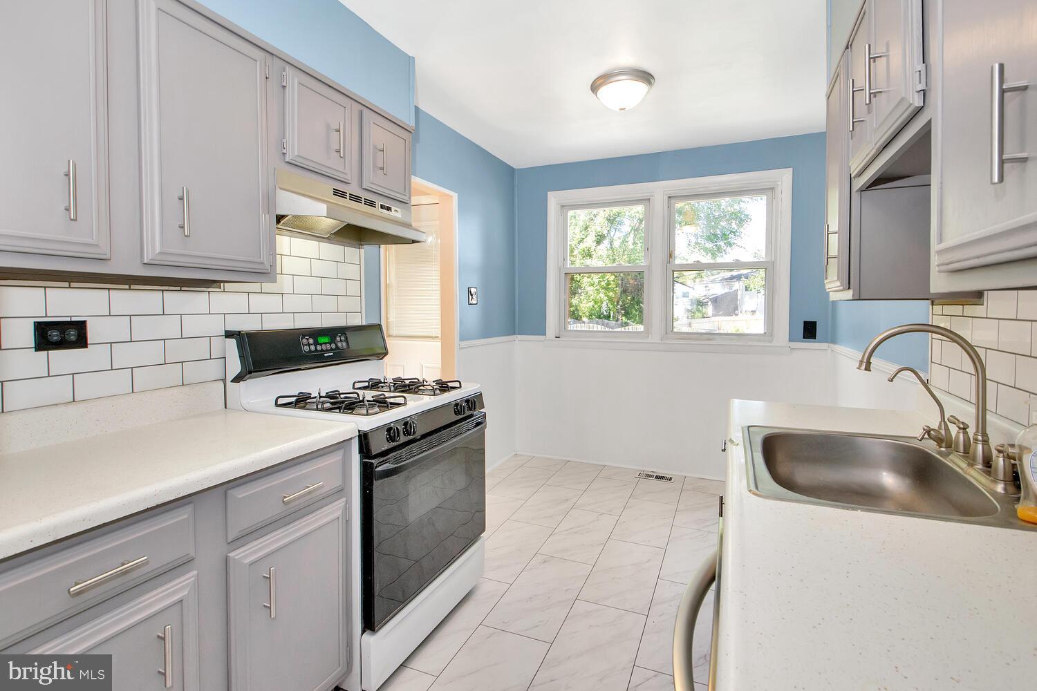 1466 Bluejay Road Abington, PA 19001 - Photo 9 of 20 a kitchen with granite countertop a sink stove a refrigerator and cabinets