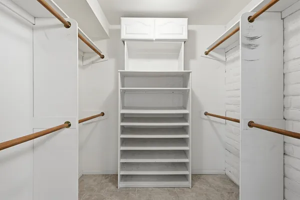a view of walk in closet with empty racks
