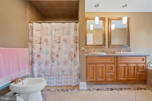 a bathroom with a granite countertop toilet and a sink