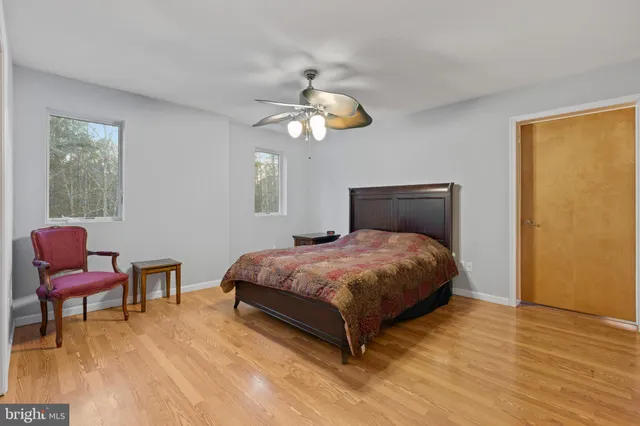 an empty room with windows and ceiling fan