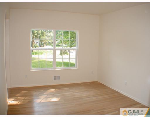 84 Harding Avenue Edison, NJ 08820 - Photo 3 of 8 a view of an empty room with wooden floor and a window
