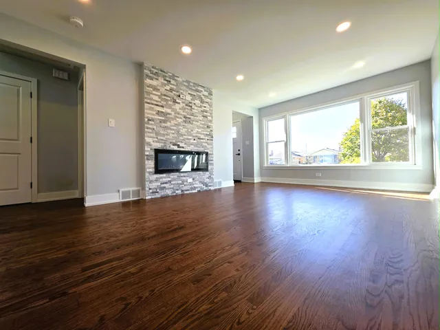 a kitchen with stainless steel appliances granite countertop a refrigerator a stove and a wooden floor