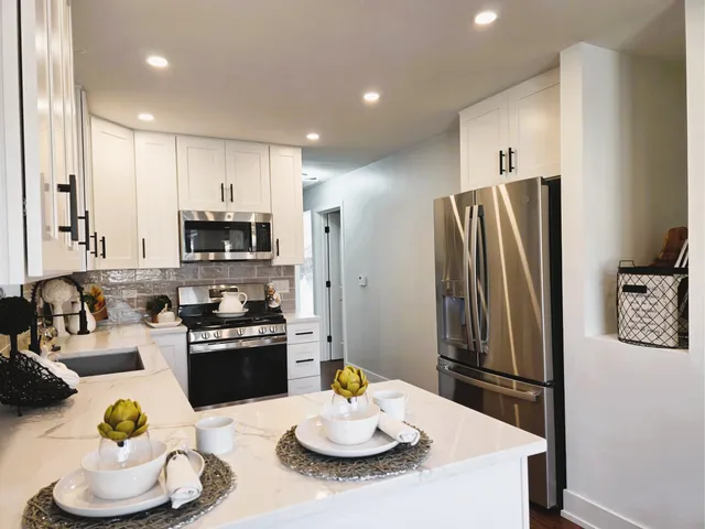 a kitchen with stainless steel appliances kitchen island granite countertop a sink cabinets and wooden floor