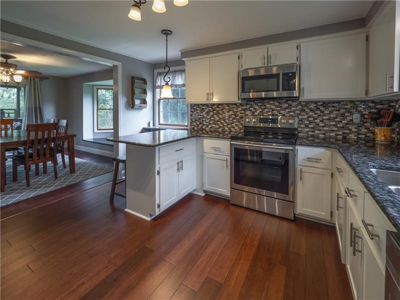 4137 Ewalt Road Gibsonia, PA 15044 - Photo 5 of 25 GORGEOUS modern kitchen updates will make any homeowner proud! Stylish flooring, shaker style cabinetry, modern hardware, new fixtures trendy and stylish backsplash, new lighting and all new Samsung SS appliances. Wow - MOVE RIGHT IN and enjoy this amazing kitchen.