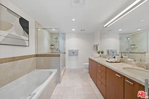 a bathroom with a double vanity sink mirror and bathtub