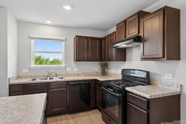a kitchen with stainless steel appliances a sink stove and cabinets