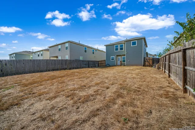 a view of backyard with wooden fence