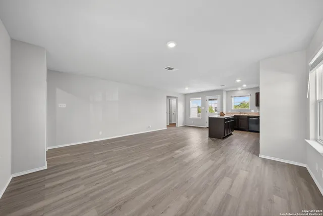 a view of a big room with wooden floor and windows