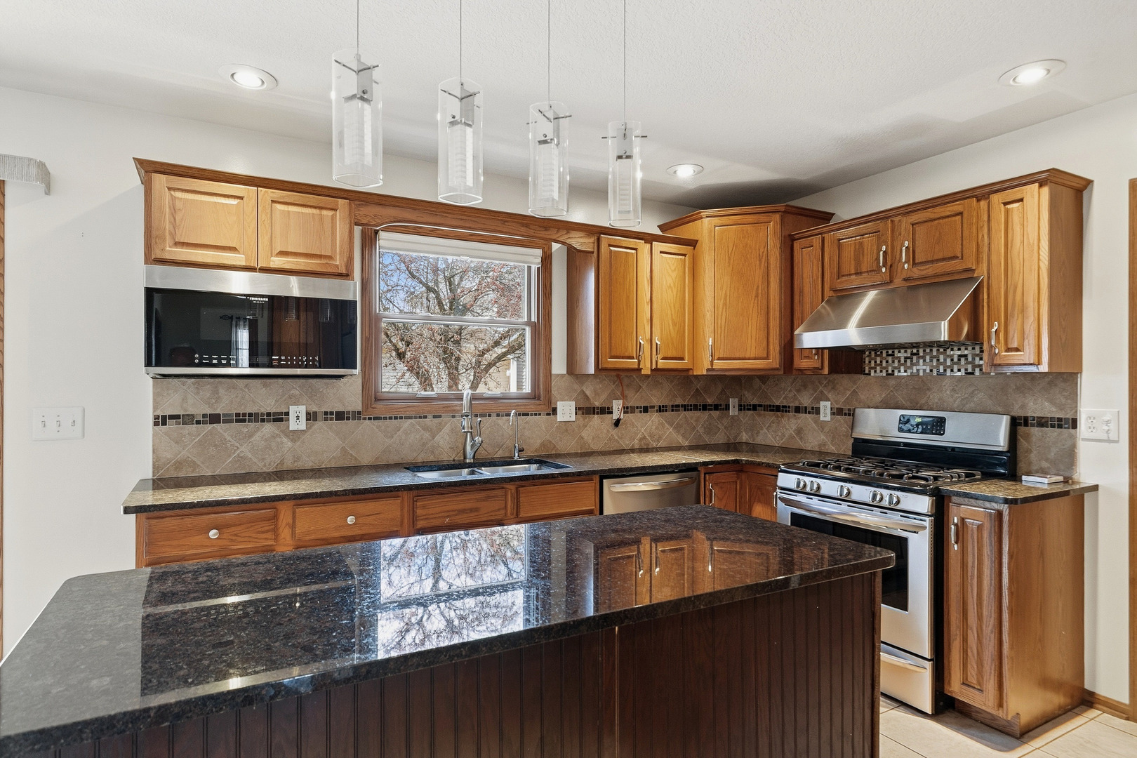 2052 Ashford Road Bettendorf, IA 52722 - Photo 20 of 40 a kitchen with stainless steel appliances granite countertop a sink a stove and a microwave oven
