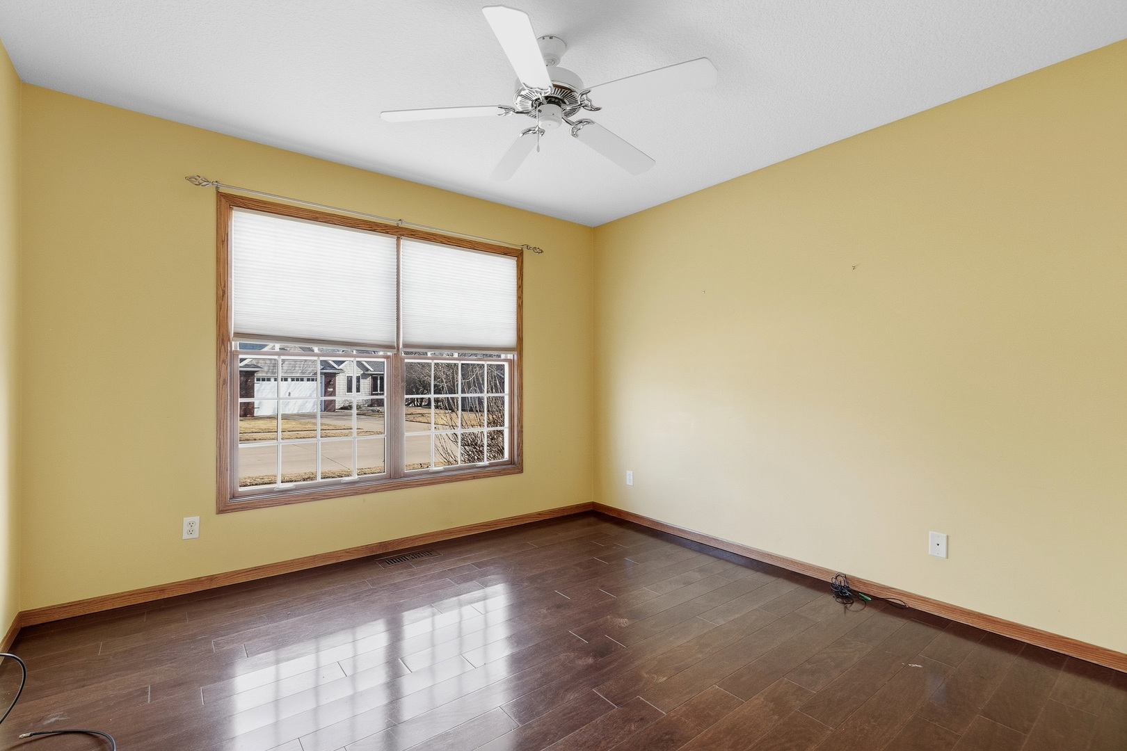 2052 Ashford Road Bettendorf, IA 52722 - Photo 9 of 40 a view of an empty room with a window and wooden floor