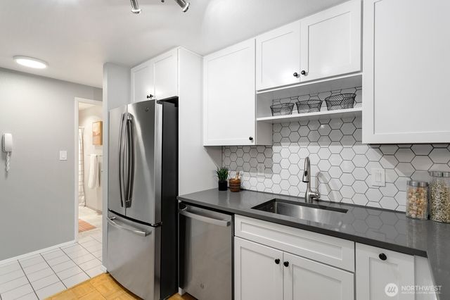 a kitchen with stainless steel appliances granite countertop white cabinets and a stove