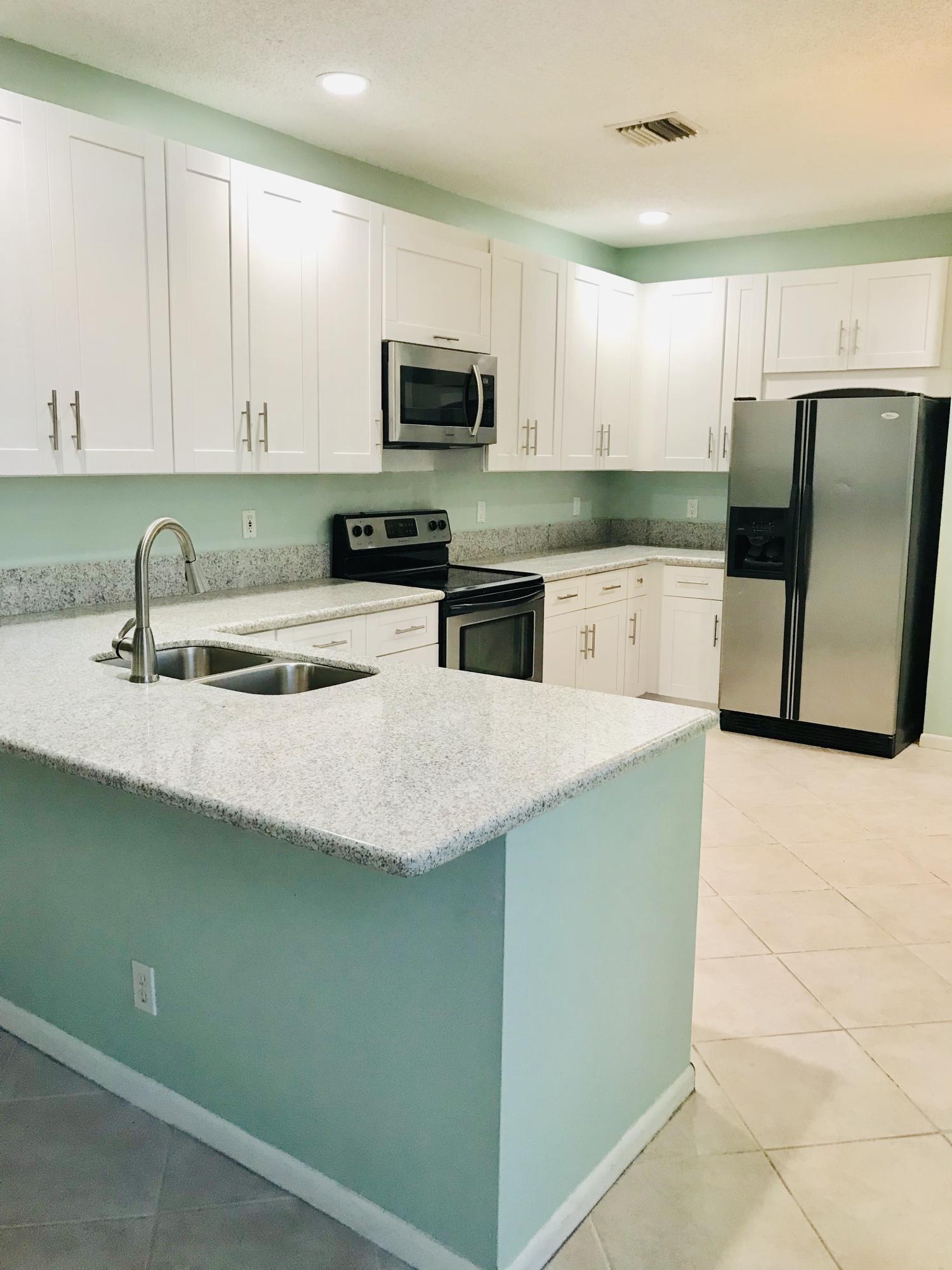 10614 Palm Spring Drive Boca Raton, FL 33428 - Photo 8 of 42 a kitchen with stainless steel appliances granite countertop a sink a stove a microwave a counter top and cabinets