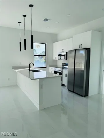 a kitchen with stainless steel appliances granite countertop a sink and a refrigerator