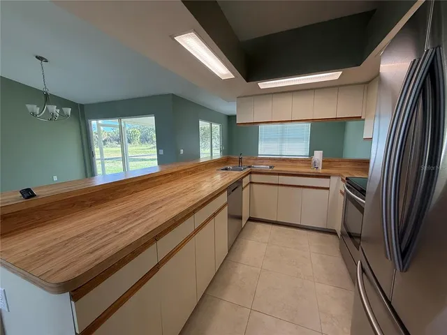a kitchen with a sink stainless steel appliances a counter space and a window