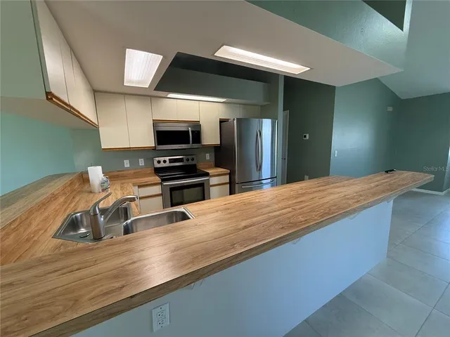 a kitchen with kitchen island white cabinets and stainless steel appliances