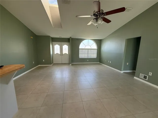 a view of a livingroom with a chandelier fan and windows