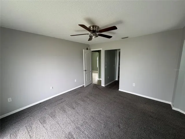an empty room with a ceiling fan and a window
