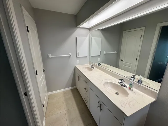 a bathroom with a double vanity sink and a mirror