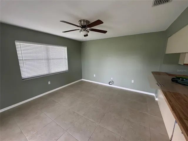 a view of a livingroom with a ceiling fan and window