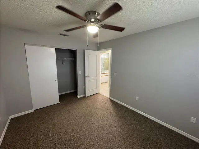 an empty room with a ceiling fan and a window