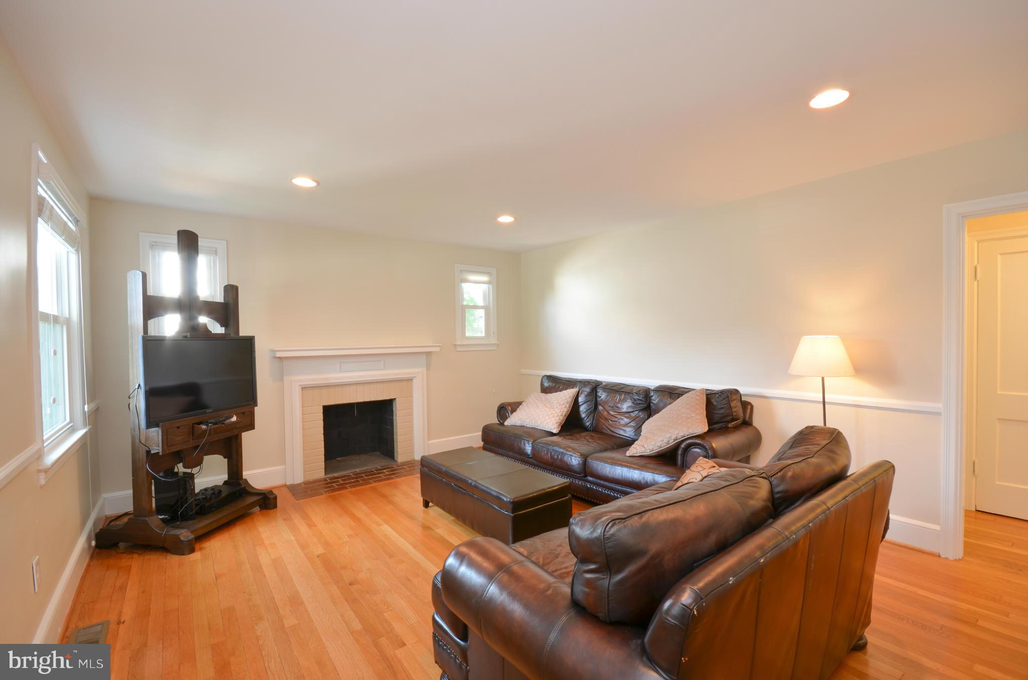 903 Forest Glen Road Silver Spring, MD 20901 - Photo 5 of 30 a living room with furniture a fireplace and a flat screen tv