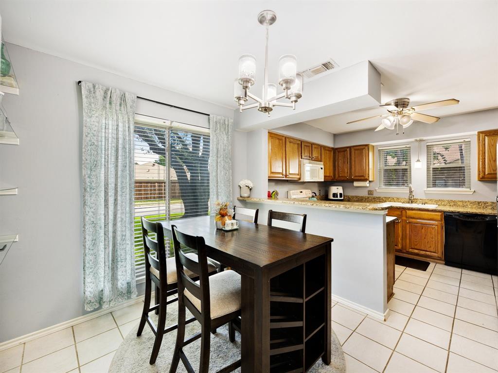 2032 Spicewood Road Bedford, TX 76021 - Photo 9 of 21 Dining area featuring a contemporary chandelier, tile flooring, and a large window