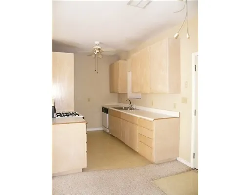 a large white kitchen with sink and cabinets