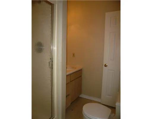 a bathroom with a granite countertop toilet and a sink