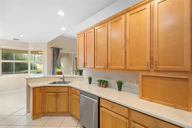 a view of an empty room with chandelier fan and a window