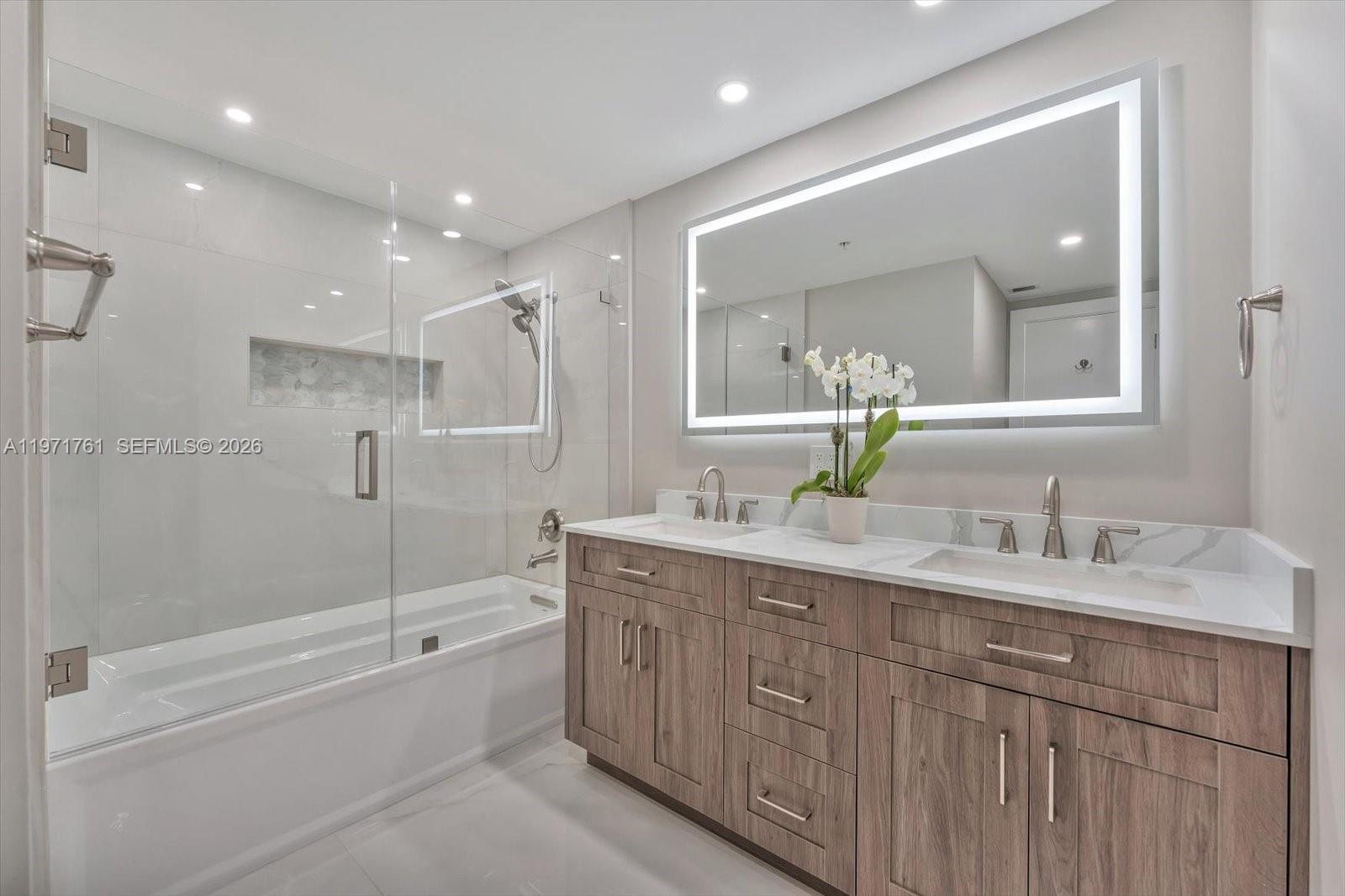 3400 Southwest 27th Avenue, Unit 602 Miami, FL 33133 - Photo 28 of 42 a bathroom with a double vanity sink mirror double and shower