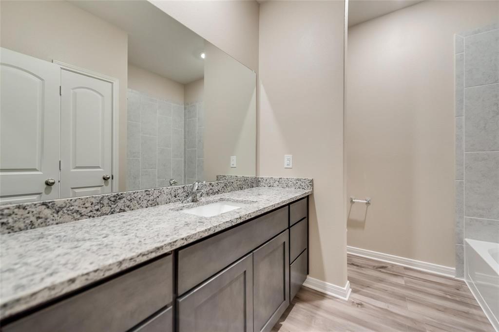 291 Wandering Stream Way Princeton, TX 75407 - Photo 11 of 22 a bathroom with a granite countertop sink and a mirror