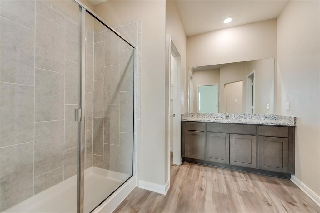 291 Wandering Stream Way Princeton, TX 75407 - Photo 17 of 22 a bathroom with a granite countertop sink mirror and shower