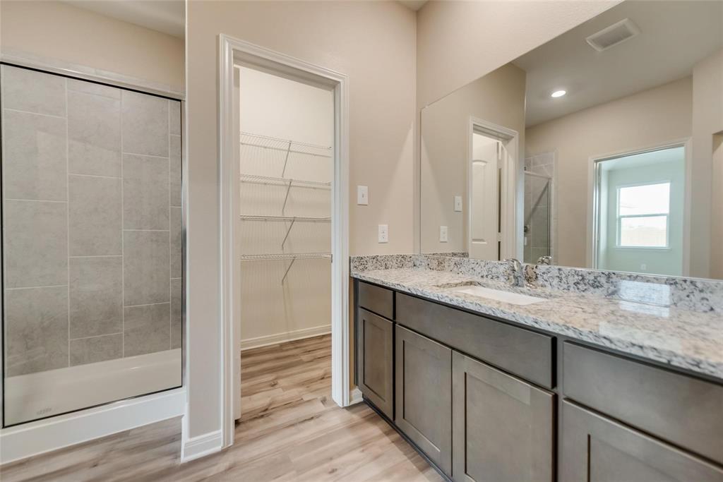 291 Wandering Stream Way Princeton, TX 75407 - Photo 18 of 22 a bathroom with a granite countertop sink and a mirror