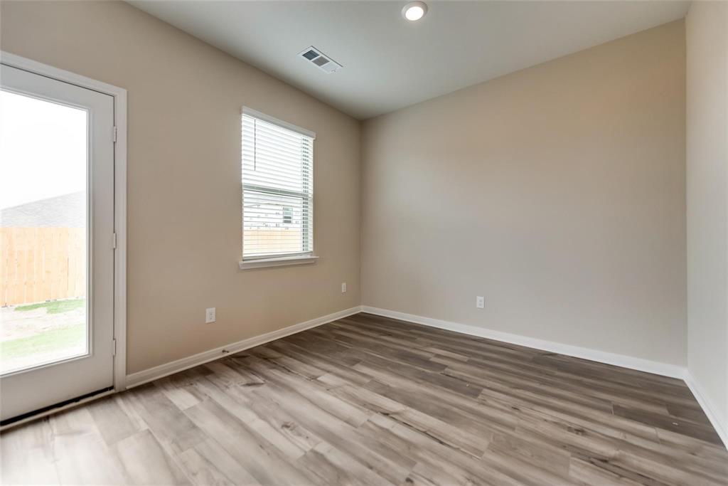 291 Wandering Stream Way Princeton, TX 75407 - Photo 6 of 22 an empty room with wooden floor and windows