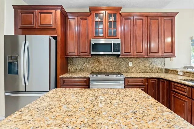 a kitchen with stainless steel appliances granite countertop a refrigerator and microwave