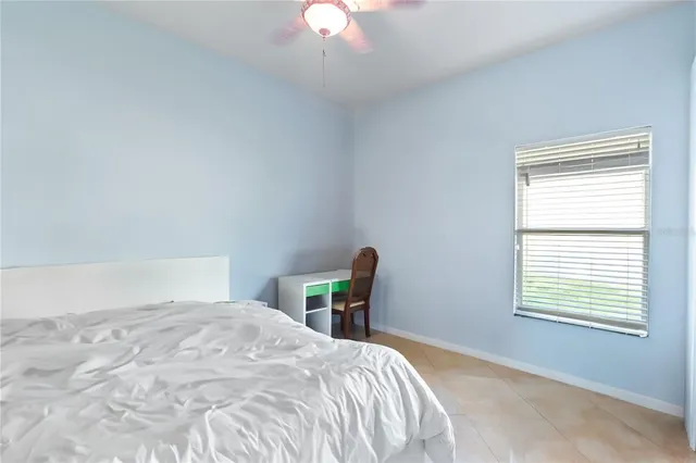 a bedroom with a bed a chandelier and a window