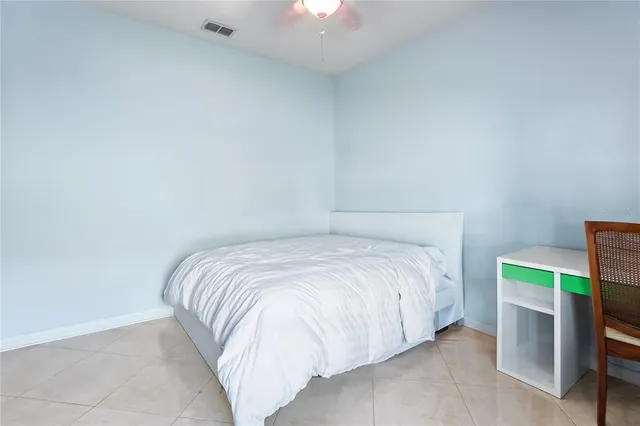 a bed sitting in a bedroom next to a lamp