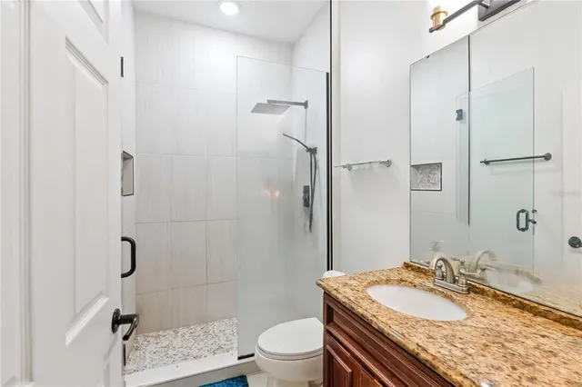 a bathroom with a granite countertop sink toilet and shower