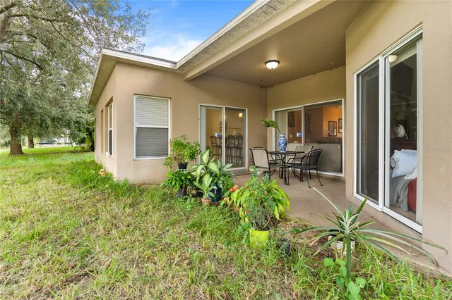 a view of a house with backyard and sitting area