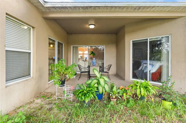 a porch with chairs and potted plant