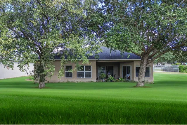 a front view of house with a garden and trees