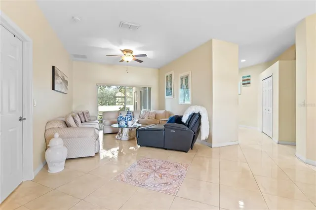a living room with furniture a chandelier and a window